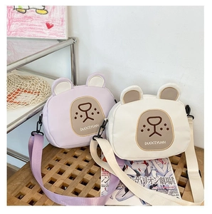 Detailed view of cute bear crossbody bags in purple and cream with adjustable straps