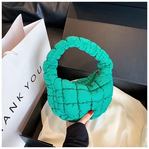 Close-up of bright green quilted mini cloud bag with ring handle and silver metal zipper