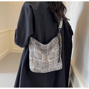 Detail of grey striped canvas crossbody bag featuring jacquard texture and star patterned strap