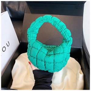 Detail of green quilted cloud bag with zipper and nylon texture in a premium gift box