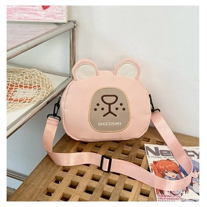 Detailed close-up of a pink cartoon bear crossbody bag with adjustable fabric strap