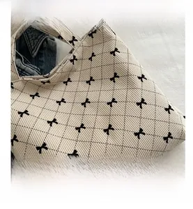 Détail du sac cabas en velours côtelé montrant le motif de losanges noirs et nœud
