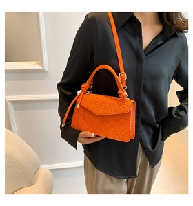 Chic orange woven leather small square bag shown with knotted handle and shoulder strap