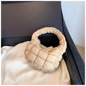 Top view of cream quilted puffer cloud bag with soft fabric texture and zipper detail