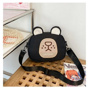 Detail view of cartoon bear crossbody bag featuring adjustable black nylon shoulder strap