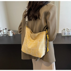 Close-up of yellow striped canvas tote bag with decorative knot and wide strap