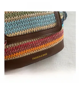Close-up of colorful striped woven raffia bag with premium leather trim and gold logo