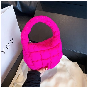 Detail view of the vibrant hot pink quilted cloud bag with puffy ruffles and top handle