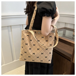 Détail du grand sac cabas en velours côtelé kaki avec motifs de nœuds noirs et surpiqûres