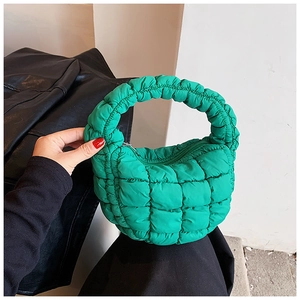 Detail of green quilted cloud bag showing puff texture and soft handle being held