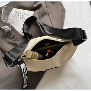 Détail du sac bandoulière beige demi-lune avec sangle noire montrant l'espace de rangement