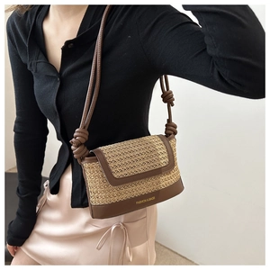 Close-up of woven straw texture and leather details on the small beige crossbody bag