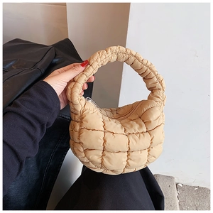Detailed close-up of a beige quilted cloud handbag featuring soft lightweight nylon texture