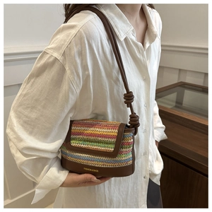 Detailed macro view of rainbow woven pattern and brown leather edges on the shoulder bag