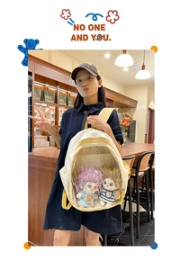 Detail view of cream and yellow canvas ITA bag featuring a transparent doll display window