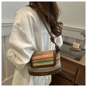 Detail of colorful woven shoulder bag with striped texture and brown leather trim accents