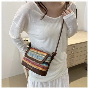Detail of colorful woven crossbody bag with brown leather strap and knotted decor