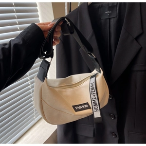 Détail du sac croissant crème en cuir grainé avec une bandoulière noire réglable