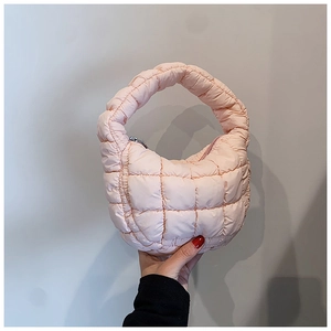Detail of light pink quilted cloud bag featuring soft puffy texture and zipper closure