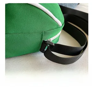 Detailed close-up of vibrant green canvas crossbody bag featuring a durable black plastic ring