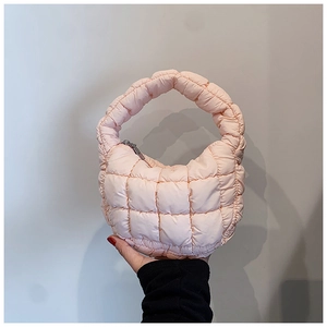 Detailed macro view of pink quilted fabric and silver metal zipper on the cloud bag