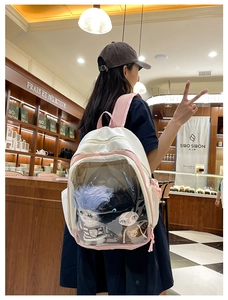 Detail view of the pink and white patchwork backpack with a clear transparent front pocket