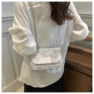 Detailed back view of a white crossbody bag with pink butterfly prints and gold hardware