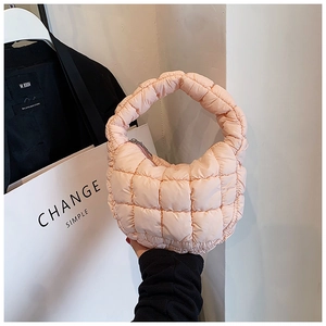 Detail of light pink quilted cloud handbag showing soft nylon texture and zipper closure