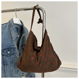 Détail du sac cabas en velours côtelé marron avec imprimés fraises et anses nouées