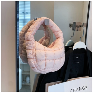 Detailed view of pink quilted cloud bag with puffy texture hanging in a stylish setting
