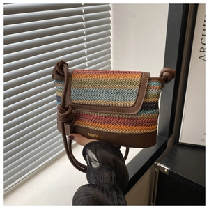 Detail of colorful woven stripe bag with brown leather base and knotted shoulder strap