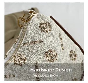 Détail de la fermeture éclair dorée sur le sac en cuir beige avec motifs imprimés