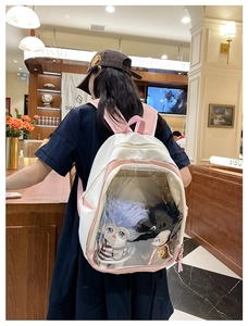 Detail of a pink and white backpack with a transparent PVC window showing plush toys inside