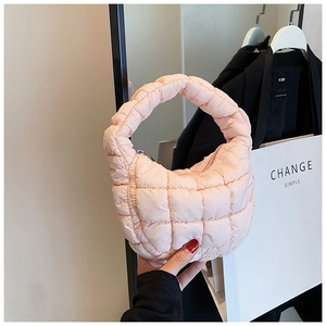 Detail of soft pink quilted puffer bag with chic square stitching and zipper closure