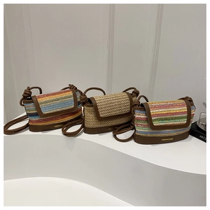 Detailed view of handmade woven straw crossbody bags with colorful stripes and leather trim