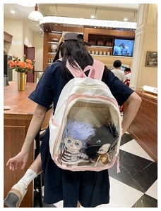 Pink and white canvas backpack with large transparent window and plush dolls view