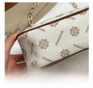 Détail des coutures précises sur sac croissant en similicuir blanc avec motif logo