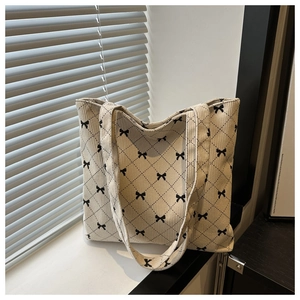 Détail du sac cabas en velours côtelé avec imprimé ruban noir et motif matelassé