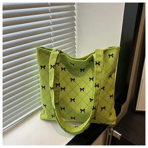 Détail du sac cabas en velours vert avec motifs nœuds noirs et surpiqûres en losange