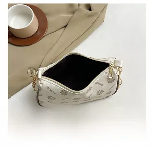 Capacité interne du sac croissant en cuir ivoire avec chaîne dorée et motifs monogramme