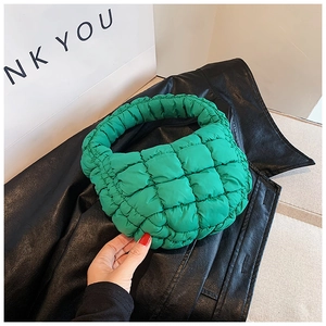 Detail shot showing the quilted vibrant green puffy handbag with thick woven fabric texture