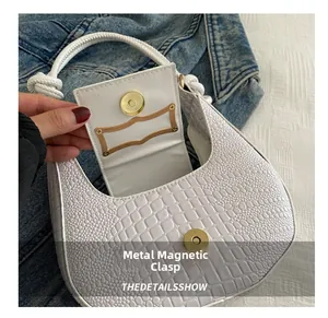 Close-up of white embossed crocodile leather bag with magnetic snap and interior card slot