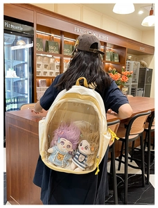 Close-up of a cartoonita style backpack with large transparent window and plush dolls