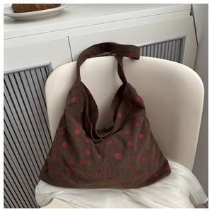 Détail de la texture d'un sac cabas en velours côtelé marron avec fraises brodées