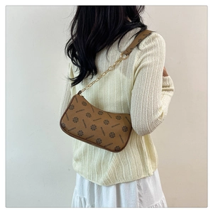 Gros plan du sac croissant monogramme marron avec bandoulière en chaîne dorée