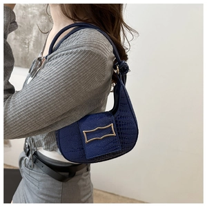 Detail view of the deep blue crocodile pattern hobo bag featuring a gold metallic clasp