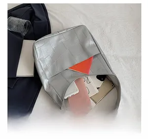 Top view of the spacious interior of the silver quilted tote bag showing daily items