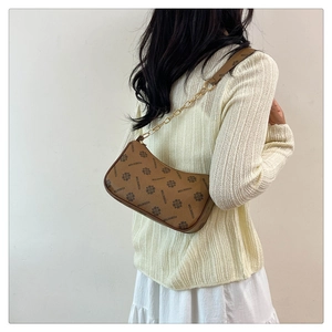Détail du sac croissant marron à monogramme avec chaîne dorée et bandoulière en cuir