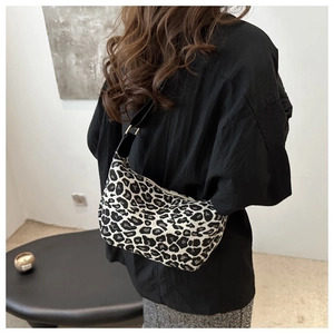 Détail du sac hobo à imprimé léopard avec texture tissu et bandoulière noire