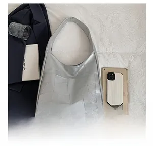 Silver patchwork shoulder bag showing large capacity space with tablet and smartphone